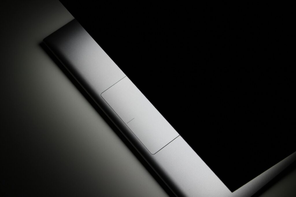 Sleek minimalist closed laptop presented in a moody dark studio setting with a focus on design.